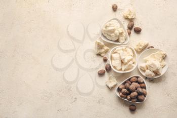 Shea butter and nuts on light background�