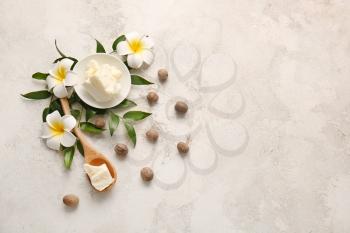 Shea butter with nuts on grey background�