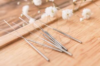 Stand with acupuncture needles on wooden background, closeup�
