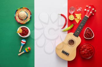 Bowls of tasty salsa sauce and symbols of Mexico on color background�