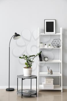 Interior of modern room with shelf unit and lamp�