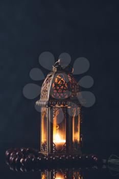 Muslim lamp and tasbih on dark background�