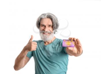 Senior man with gift card showing thumb-up on white background�