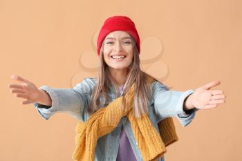 Young woman opening arms for hug on color background�