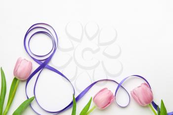 Figure 8 made of violet ribbon and tulip flowers on light background. International Women's Day celebration�