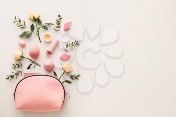 Cosmetic bag and flowers on white background�