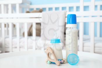 Bottles of milk for baby on table in room�