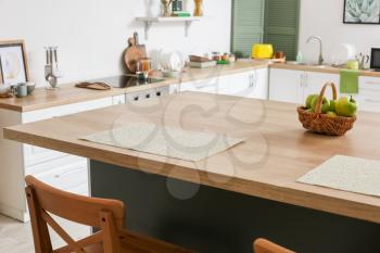 Dining table with apples in interior of modern kitchen�