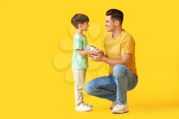 Little boy greeting his dad on Father's Day against color background�