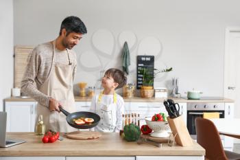 Father and his little son cooking in kitchen�