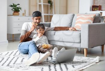 Father and little son watching movie at home�