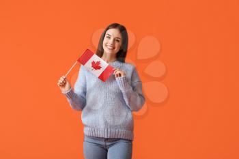 Beautiful young woman with Canadian flag on color background�