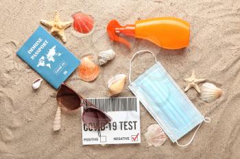 Immune passport, covid-19 test result and medical mask on beach�