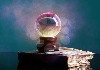 Spell book, crystal ball of fortune teller and cards on table�