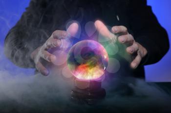 Fortune teller with crystal ball on color background, closeup�
