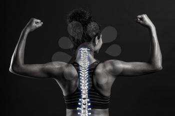Sporty African-American woman with good posture on dark background, black and white effect�