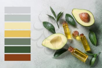 Composition with bottles of essential oil and avocado on color background. Different color patterns�