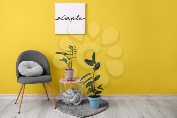 Trendy interior of living room with grey chair and yellow wall�
