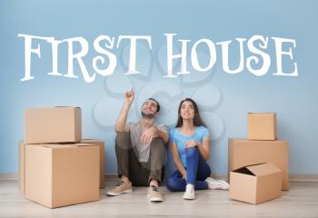 Young couple resting near boxes indoors. Moving into first house�