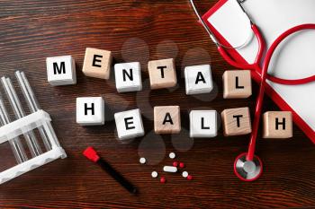 Cubes composed words MENTAL HEALTH on wooden table�