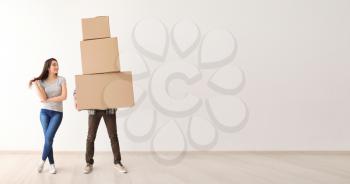 Young couple with boxes indoors. Moving into new house�