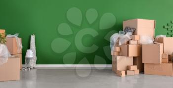 Carton boxes and interior items prepared for moving to new flat near color wall�