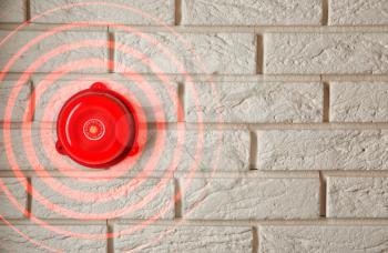 Ringing alarm bell on brick wall indoors�