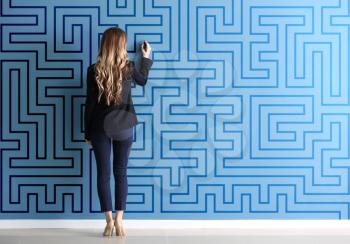 Woman in formal clothes drawing on color wall. Concept of business plan development�