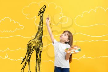 Little girl painting giraffe on color background�