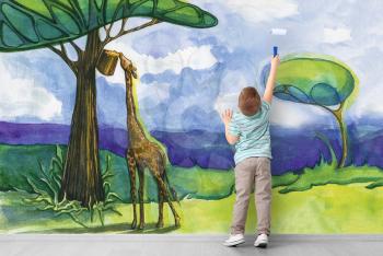 Cute little boy painting African savanna on wall �