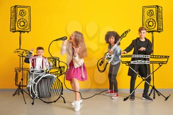 Teenage musicians with drawing instruments playing against color wall�
