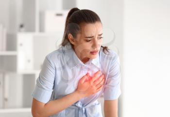 Young woman suffering from heart attack at home�