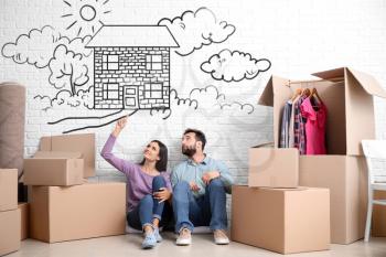 Young couple with belongings dreaming about moving into new house�
