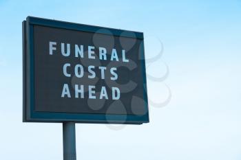 Advertising billboard with text FUNERAL COSTS AHEAD outdoors�