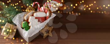 Box with tasty Christmas cookies on wooden table�