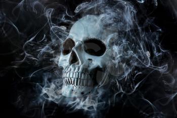 Human skull with smoke on dark background�