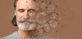 Crumbling mature man on color background. Process of aging�