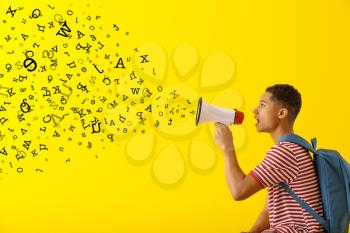 African-American teenage boy with megaphone and letters on color background�