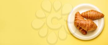 Plate with sweet croissants on color background with space for text�
