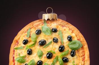 Christmas ball made of tasty pizza on dark background�