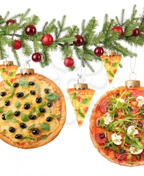Creative composition with Christmas balls and tasty pizzas hanging on fir tree branch against white background�