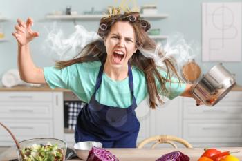 Aggressive young housewife with steam coming out of ears in kitchen�