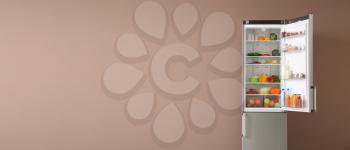 Open fridge full of food on color background with space for text�