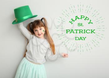 Funny little girl and text HAPPY ST. PATRICK'S DAY on white background�