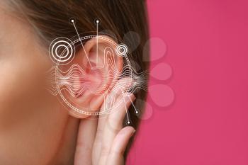 Young woman with hearing problem on color background, closeup�