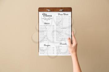 Female hand with menu on color background�