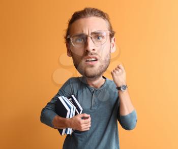Stressed male student with big head on color background�