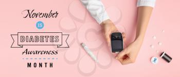 Hands of doctor with glucometer and text NOVEMBER IS DIABETES AWARENESS MONTH on color background�
