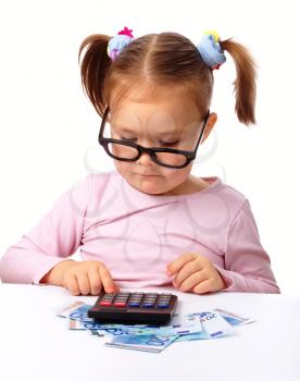 Royalty Free Photo of a Little Girl With Money and a Calculator