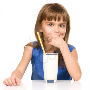 Cute little girl drinks milk using a drinking straw, isolated over white